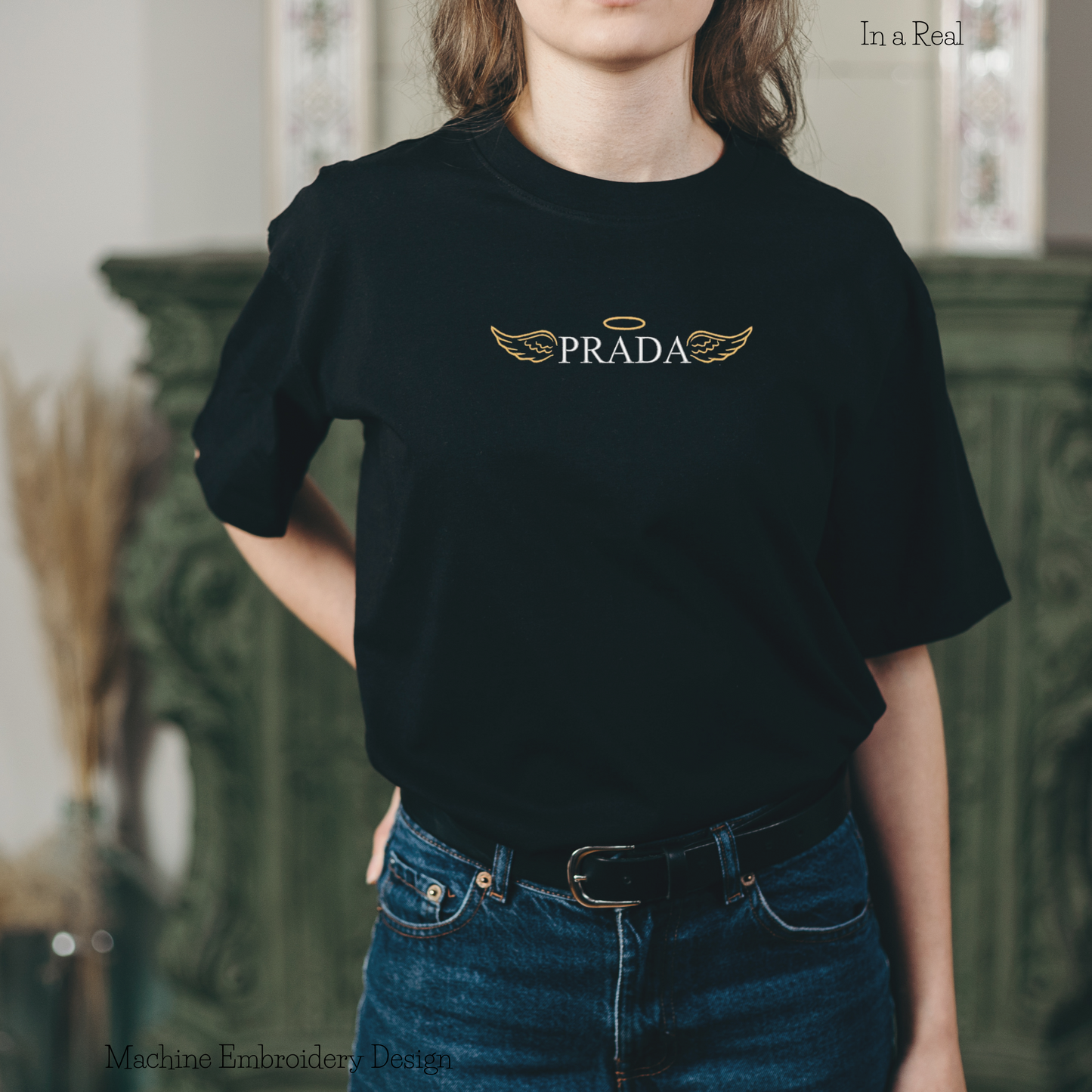 Prada logo parody machine embroidery design with angel wings and a halo displayed on a T-Shirt