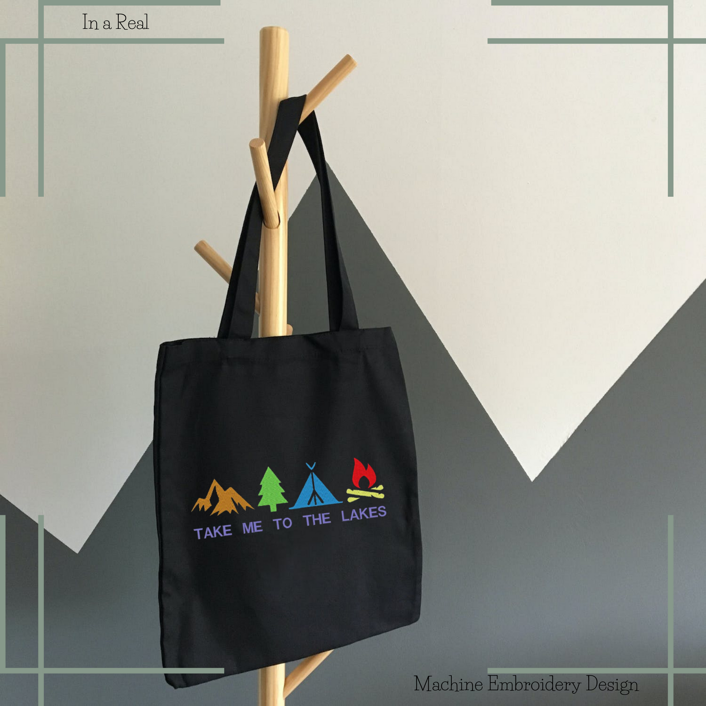 Embroidery design featuring mountain, tree, tent, and campfire illustrations, with the phrase 'Take me to the lakes', displayed on a tote bag