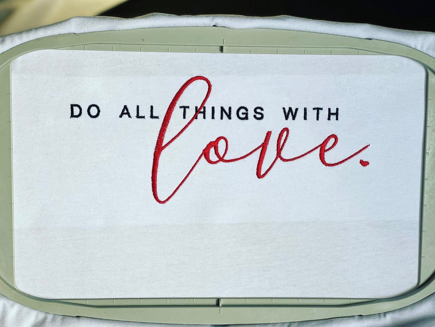 Embroidery design with the phrase 'Do all things with love' written in stylish lettering