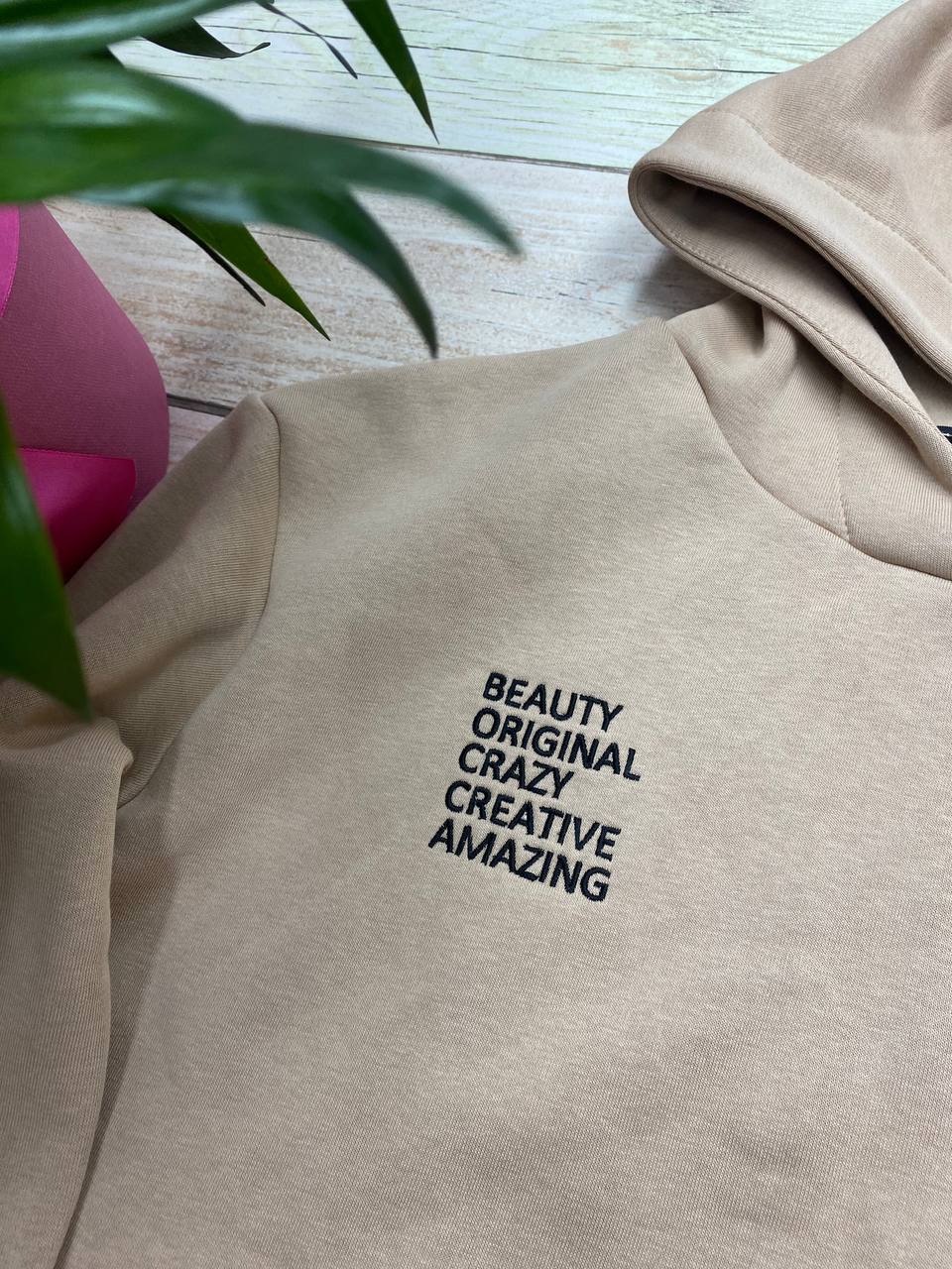 Machine embroidery design featuring the text "Beauty Original Creazy Creative Amazing"  displayed on a hoodie